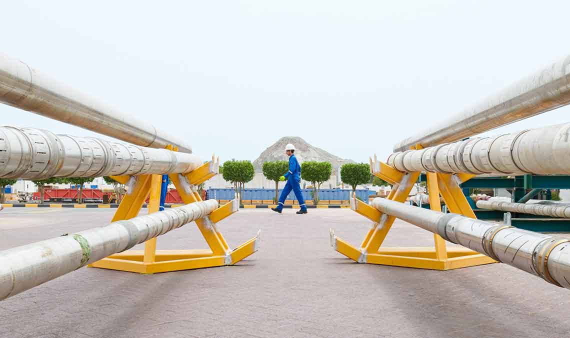 An SLB operator walking pass equipment in a manufacturing yard