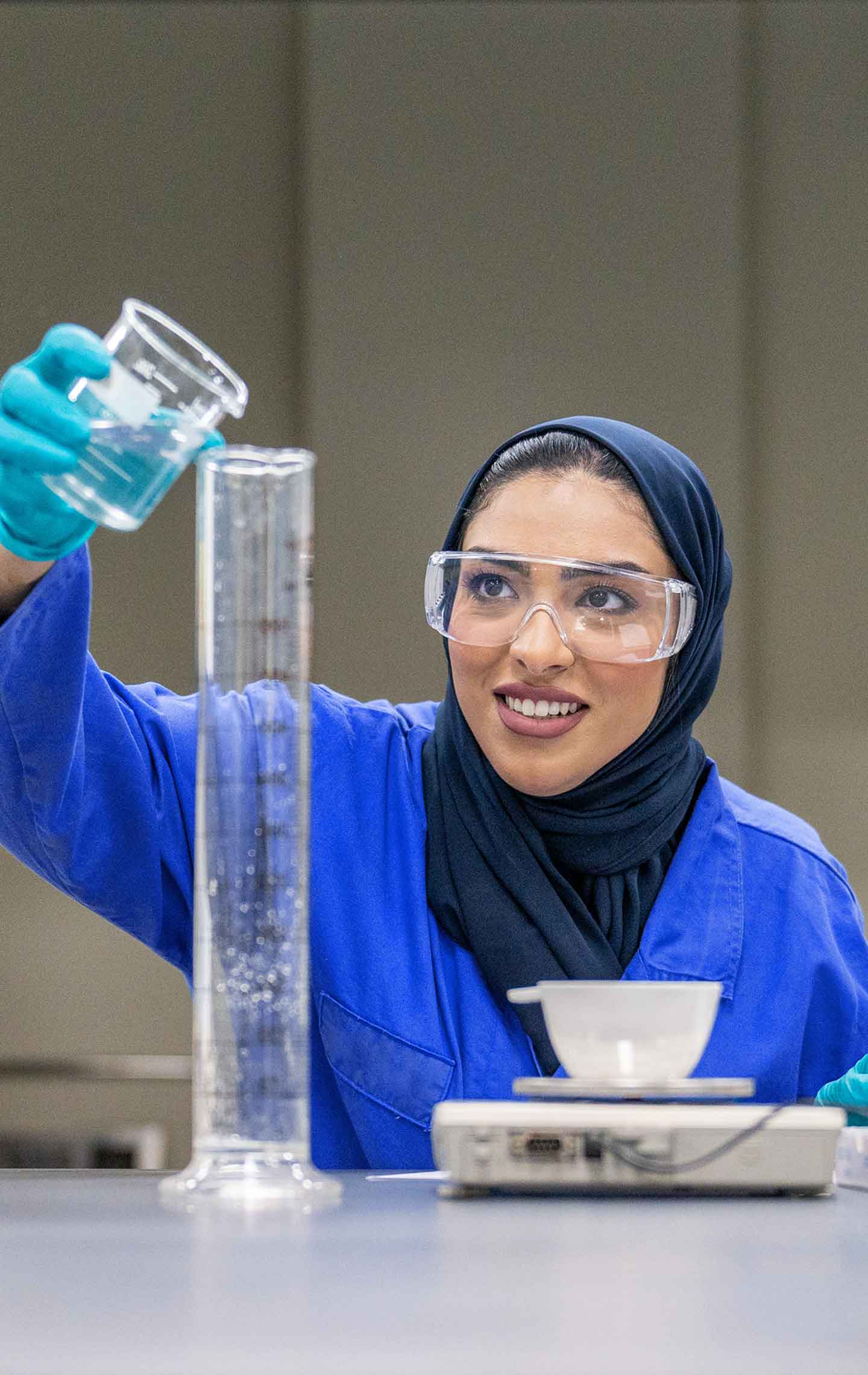 An SLB employee pouring liquid in a measuring tube