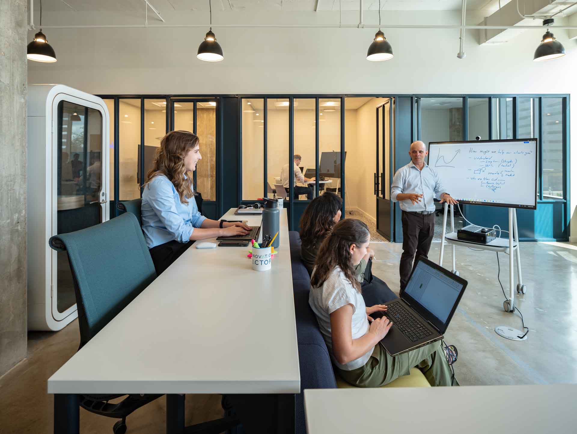 People sitting in an office setting working on laptops