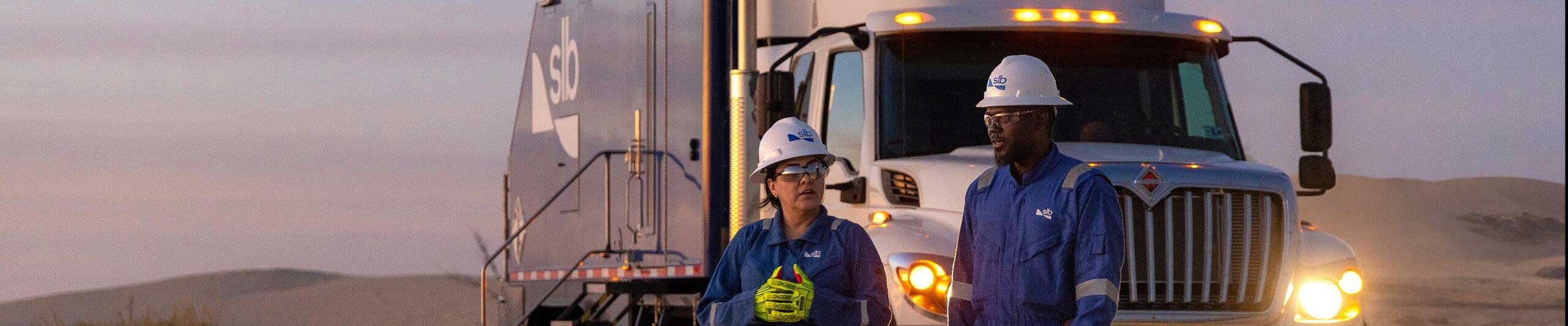 two people stood in front of a SLB lorry
