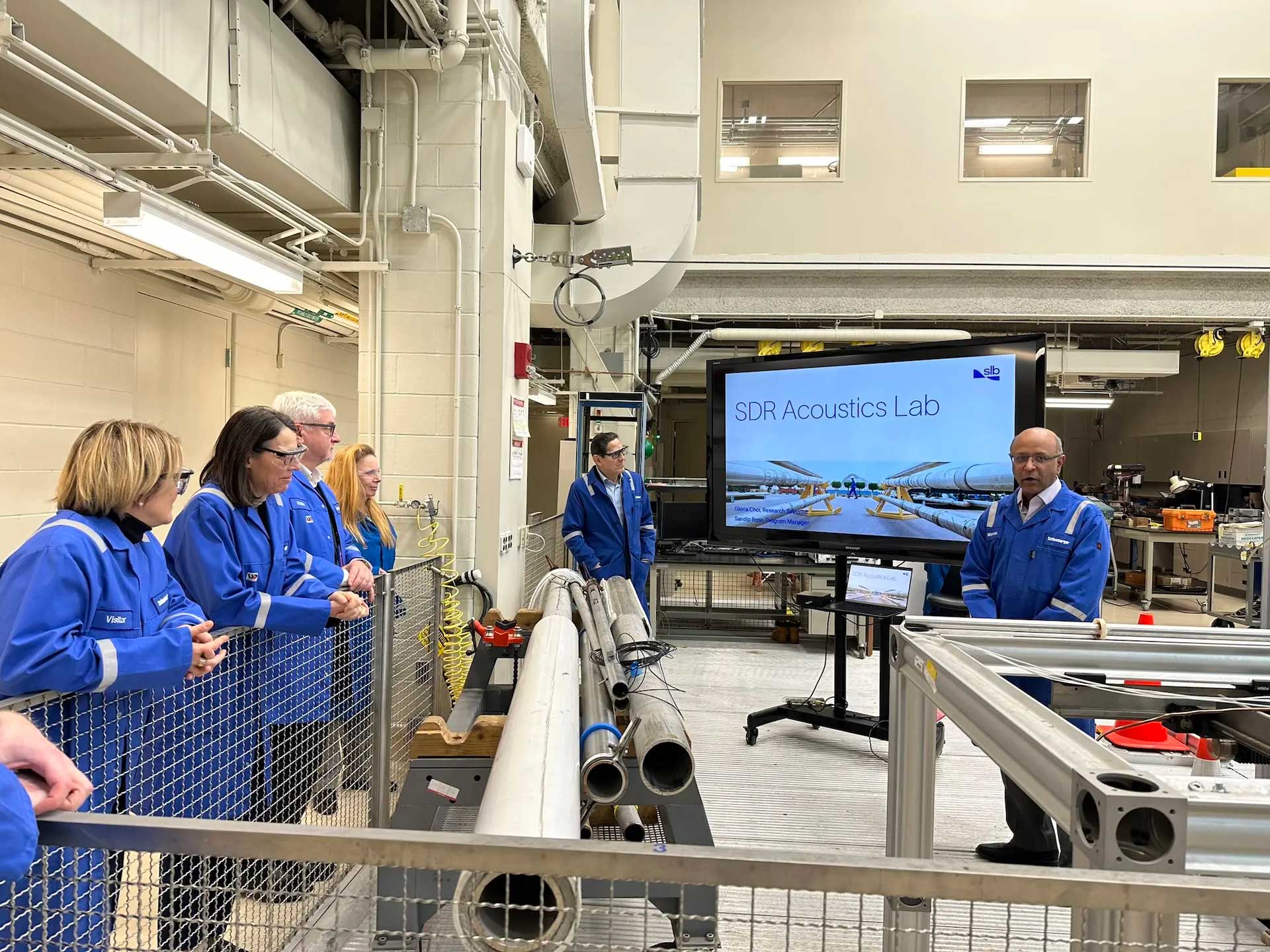 Group of people stood around a screen in a lab