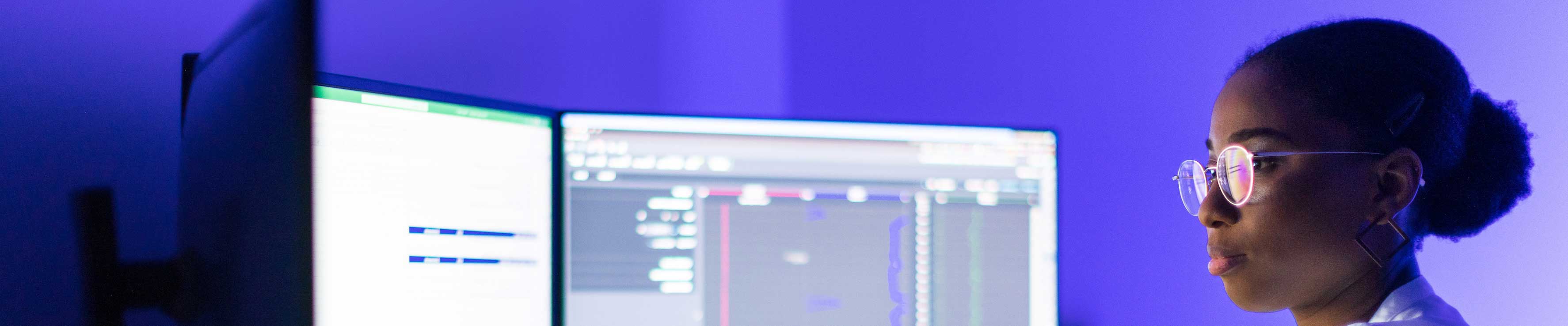 Girl sat at computer with two screens