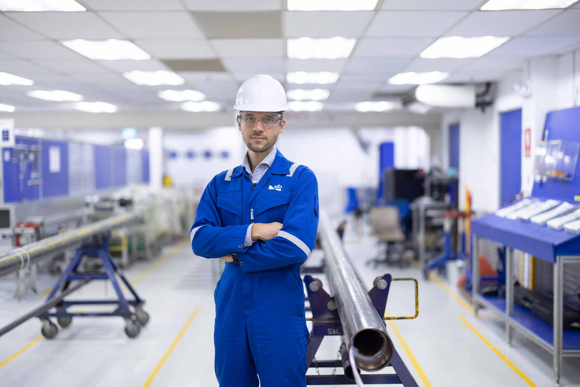 SLB operator posed in front of ESPs in a manufacturing facility