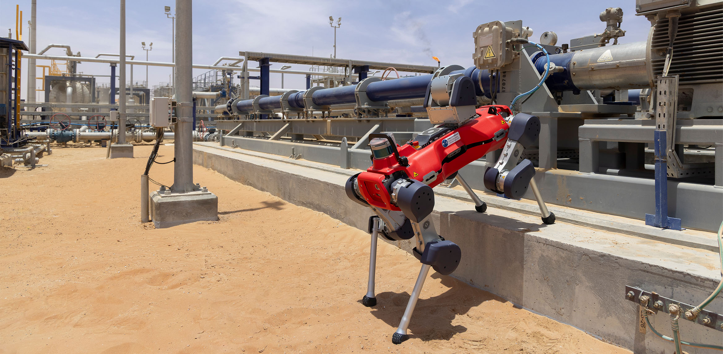 Photograph shows a robot inspecting an installed Reda HPS pumping system in the field.