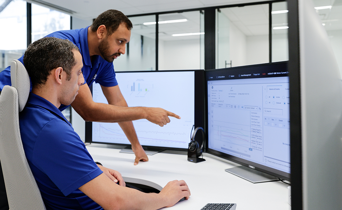 Two Performance Live center experts discussing displays on monitors.