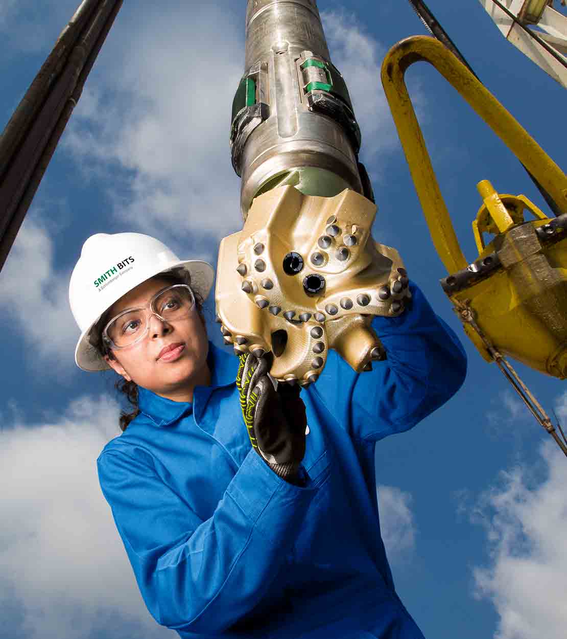 StingBlade - combo - female worker holding StingBlade drill bit on a rig.