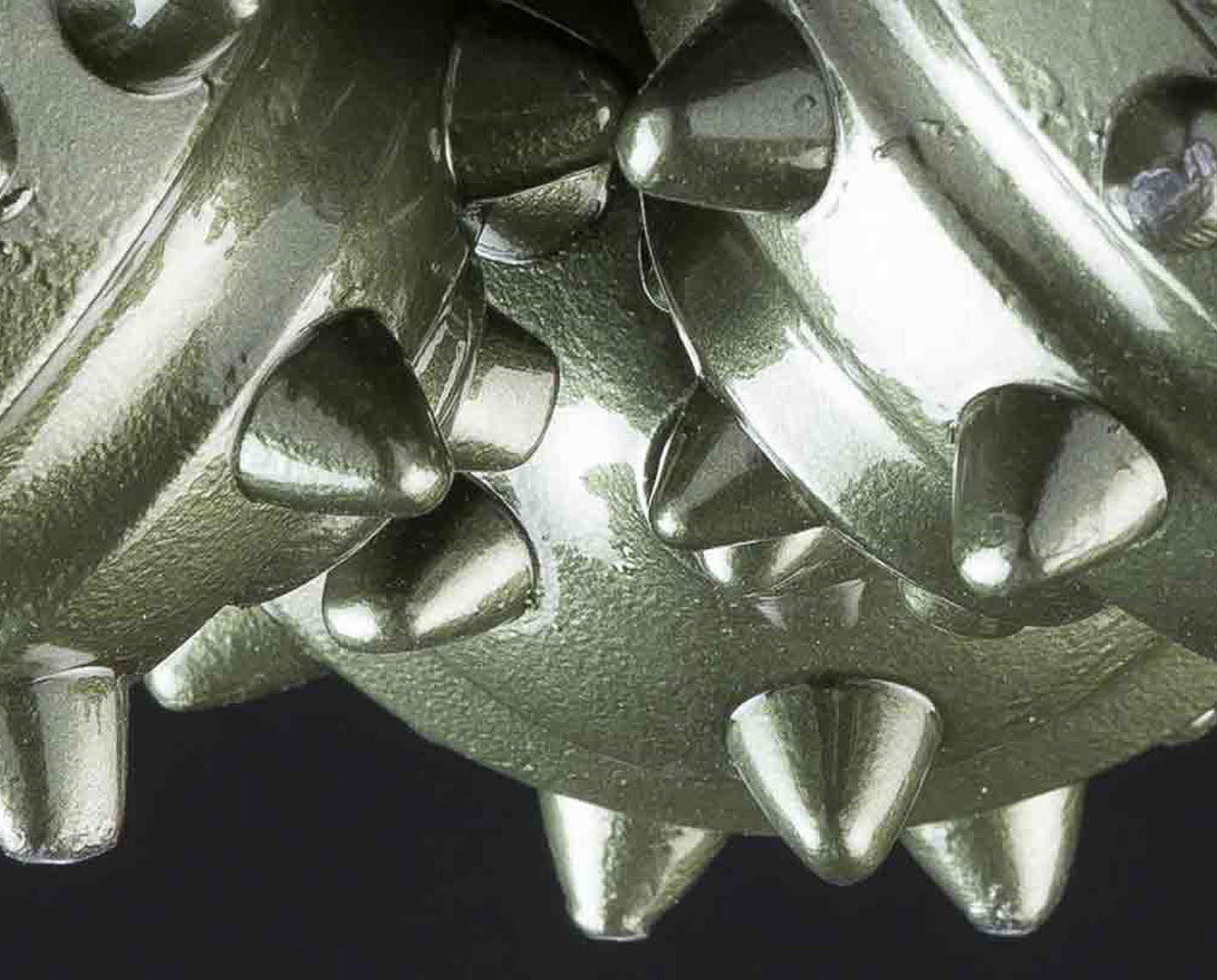 Closeup of tricone roller cone bit showing cutting structure