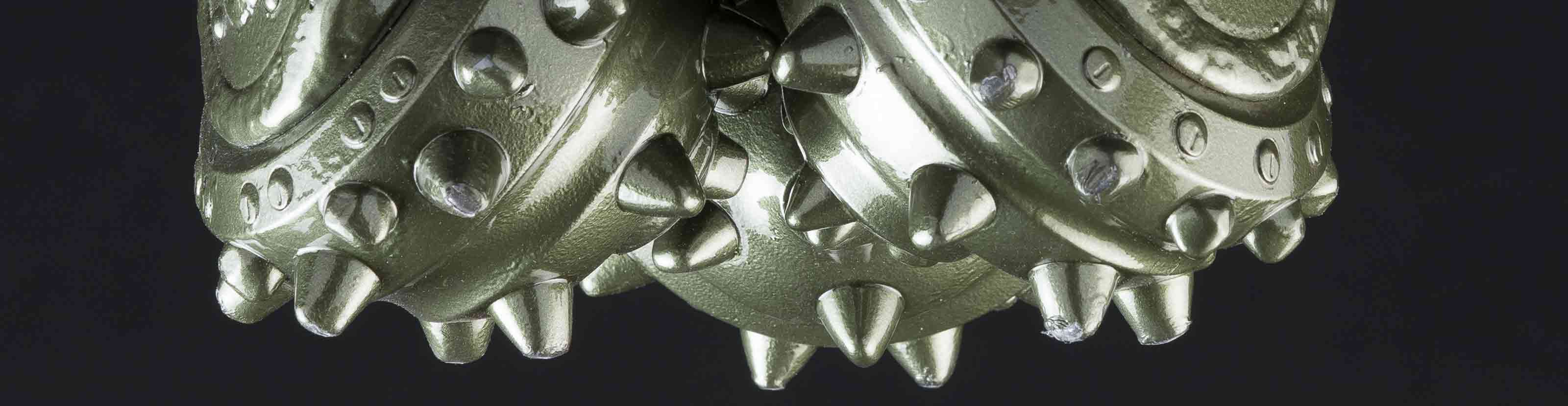 Closeup of tricone roller cone bit showing cutting structure