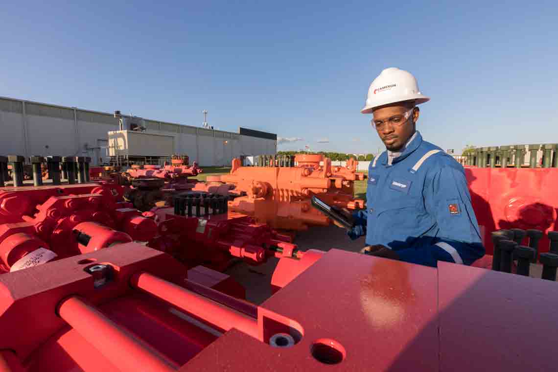 Cameron worker inspecting red BOPs