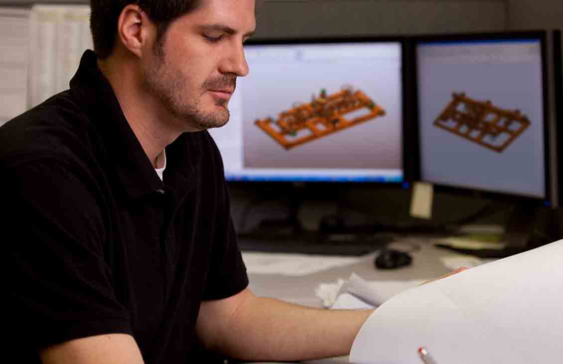 Employee looking at MPD Manifolds on his computer screen.