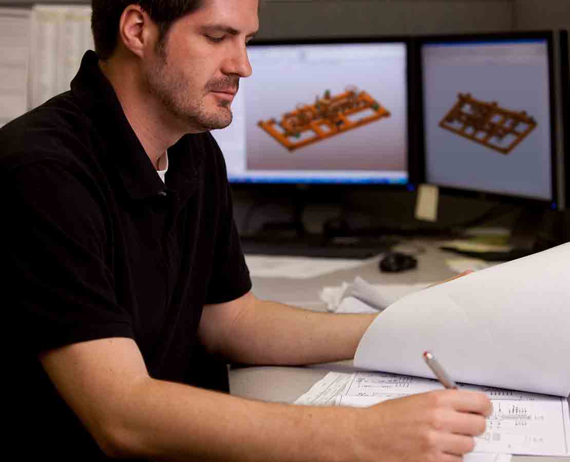 Employee looking at MPD Manifolds on his computer screen.