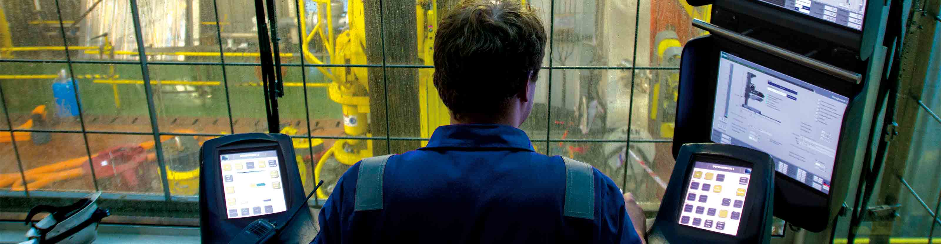 Over-the-shoulder view of an operator inside the drilling control room