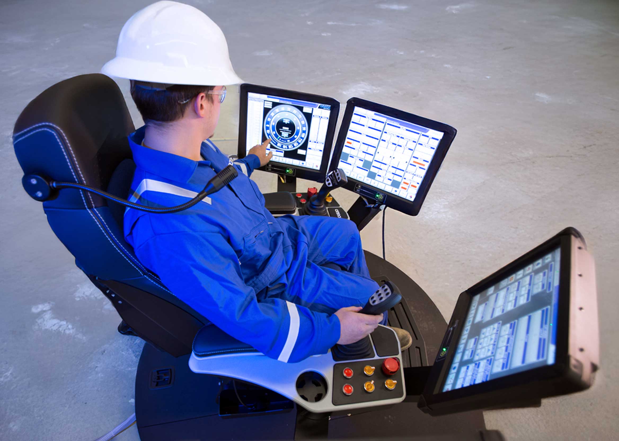 Photo of man sitting in chair watching drilling functions on multiple computer displays.