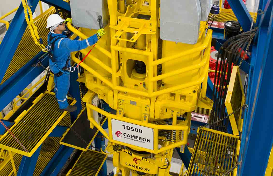 Technician working on a top drive wearing safety equipment