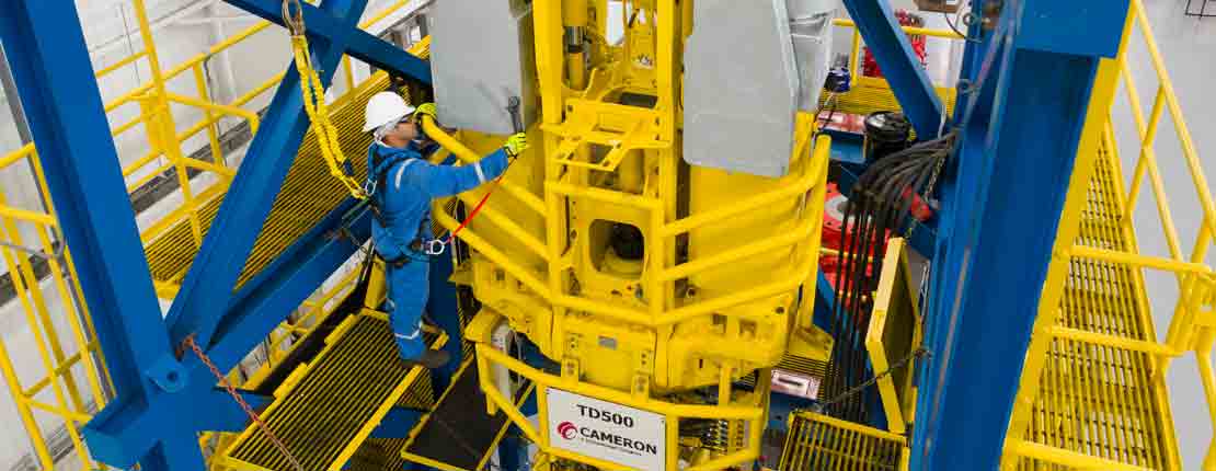 Technician working on a top drive wearing safety equipment