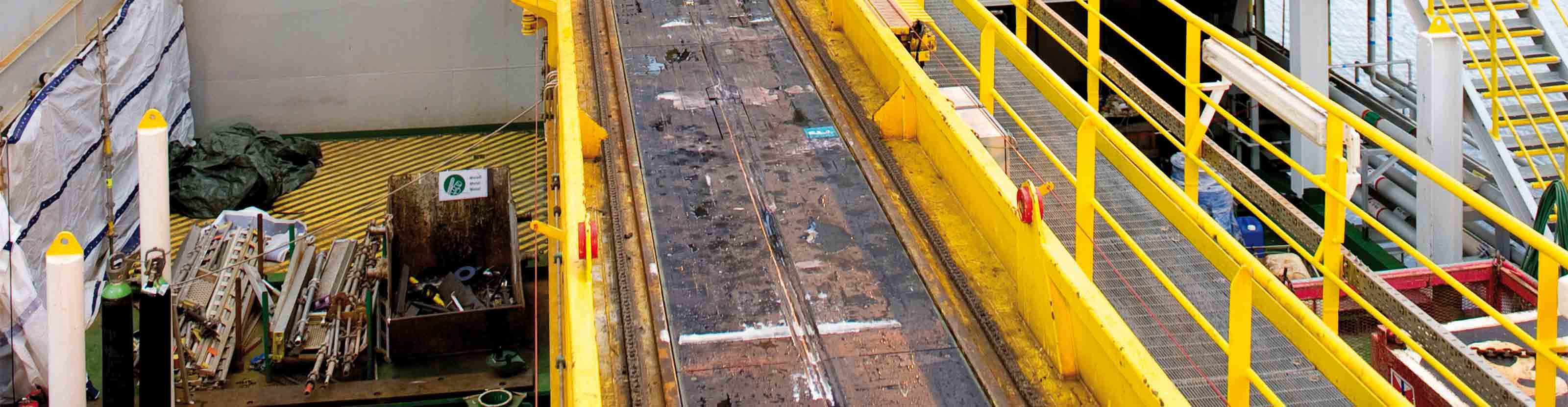 The catwalk machine runs horizontal from the pipe rack area onto the drillfloor