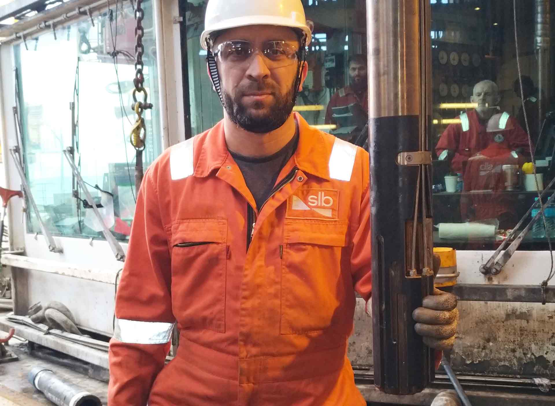 Photo of SLB operator on rig floor holding a CLWM connector before running it in the hole.
