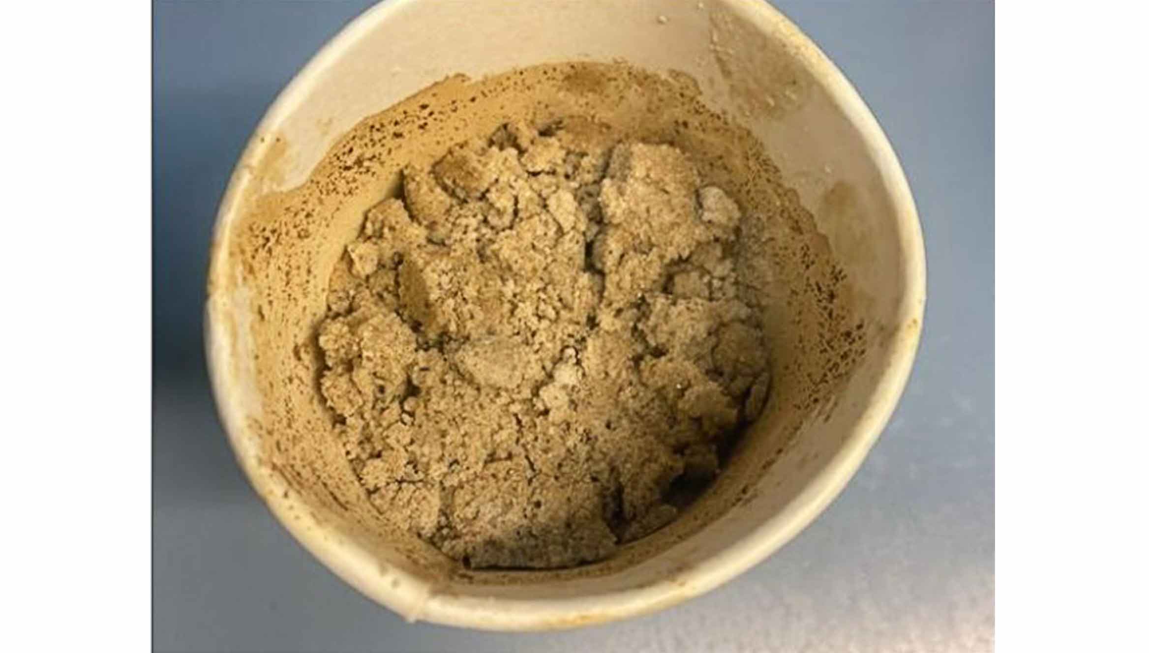 Sample of produced sand in a cup.
