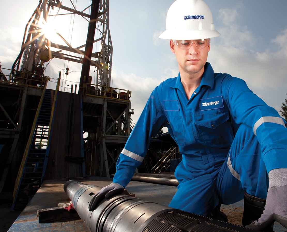 Schlumberger Worker On Rigsite Inspecting Tool