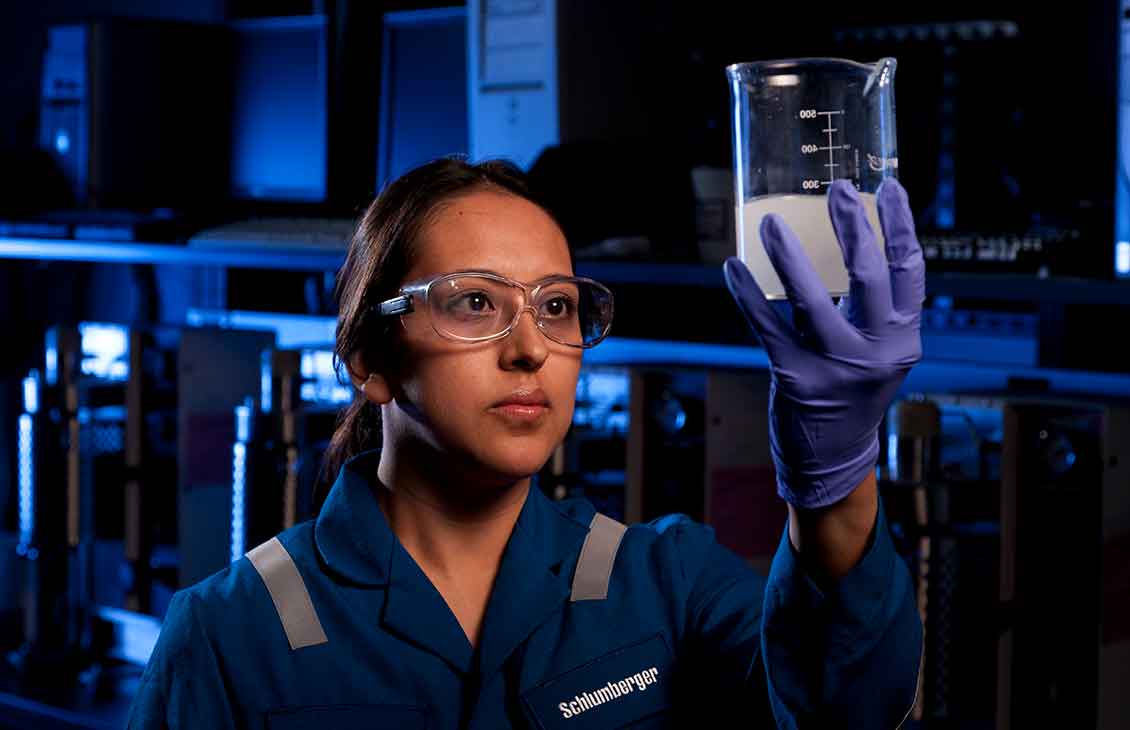 Schlumberger Lab Worker Looking at Fluid in Glass Beaker