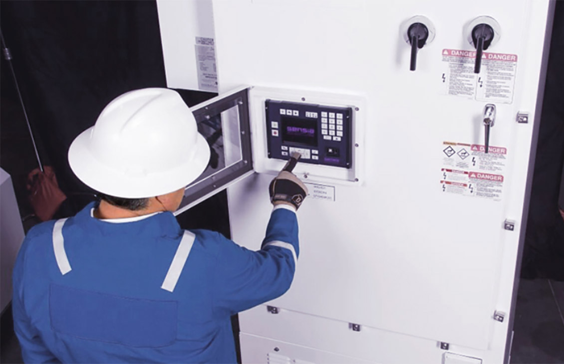 Schlumberger field worker looks at metering equipment.