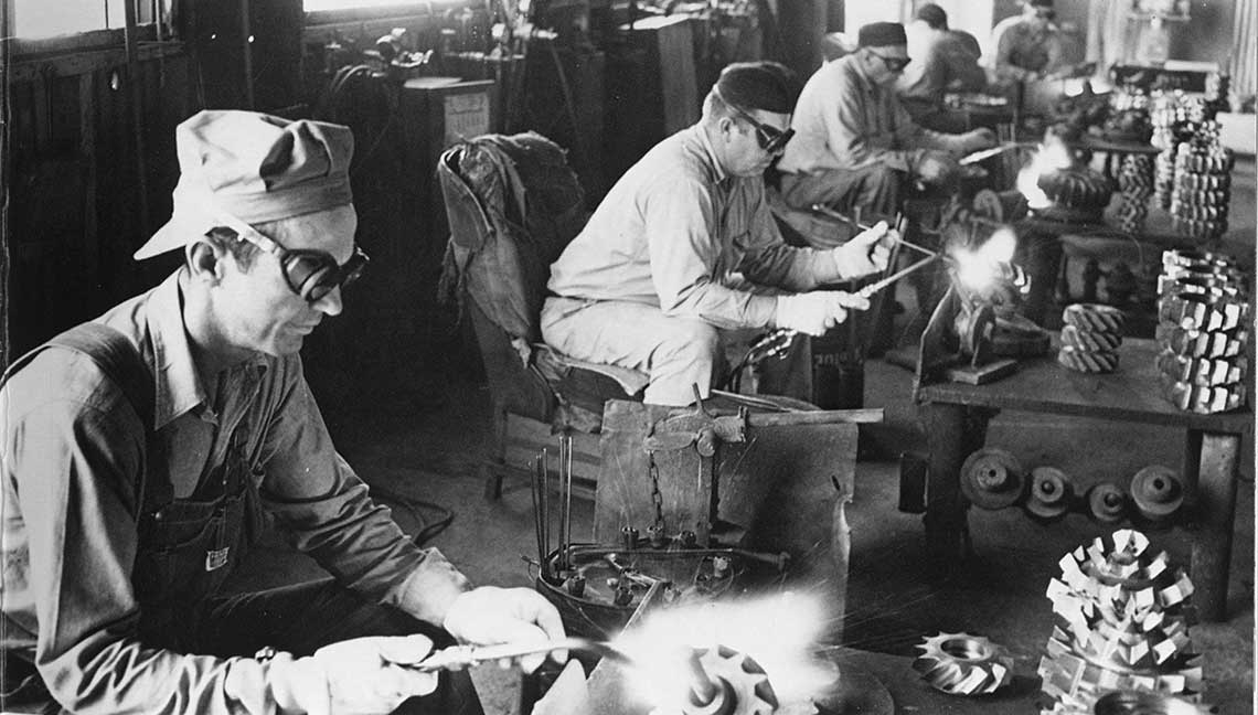 A glimpse into Smith’s drive for excellence: employees at hardfacing tables, ensuring robust products for challenging drilling environments.