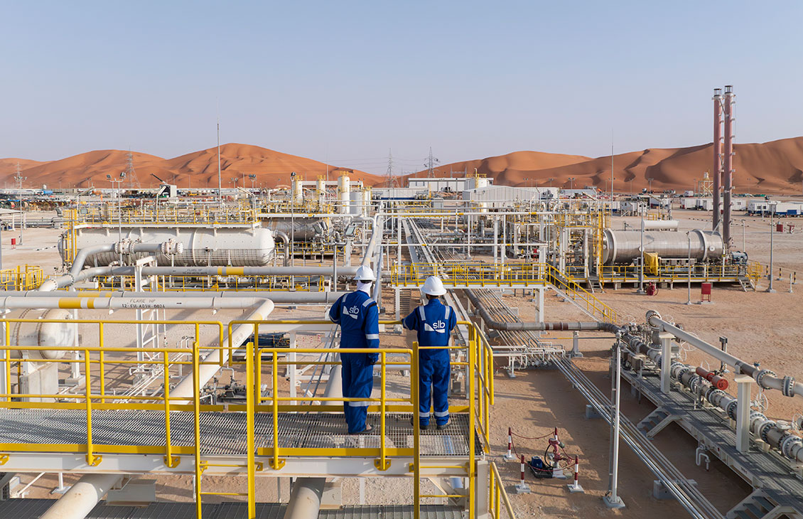 Two SLB workers in a pipeline field