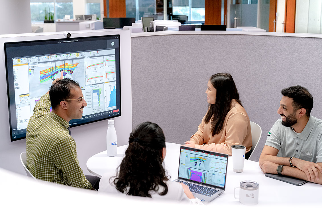 Office workers gathered around a screen