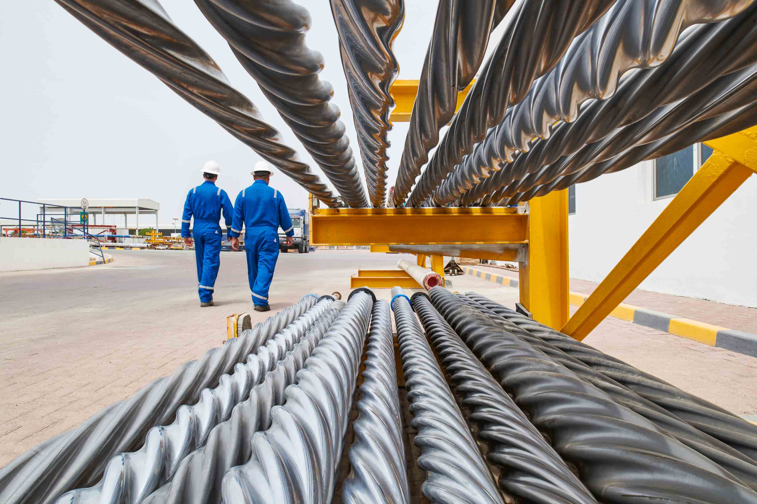 2 workers walking down an aisle of parts