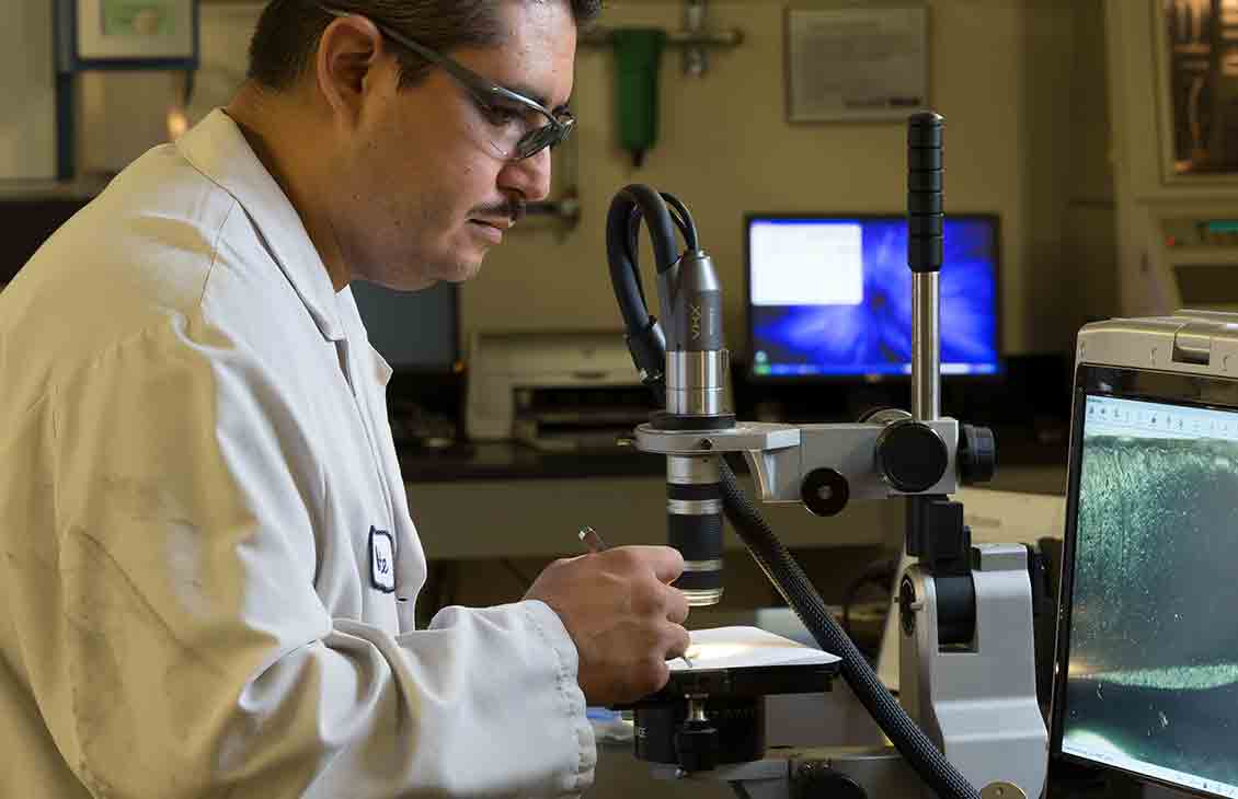 An engineer uses a digital microscope to examine a component of the DynaForce Flex drilling motor