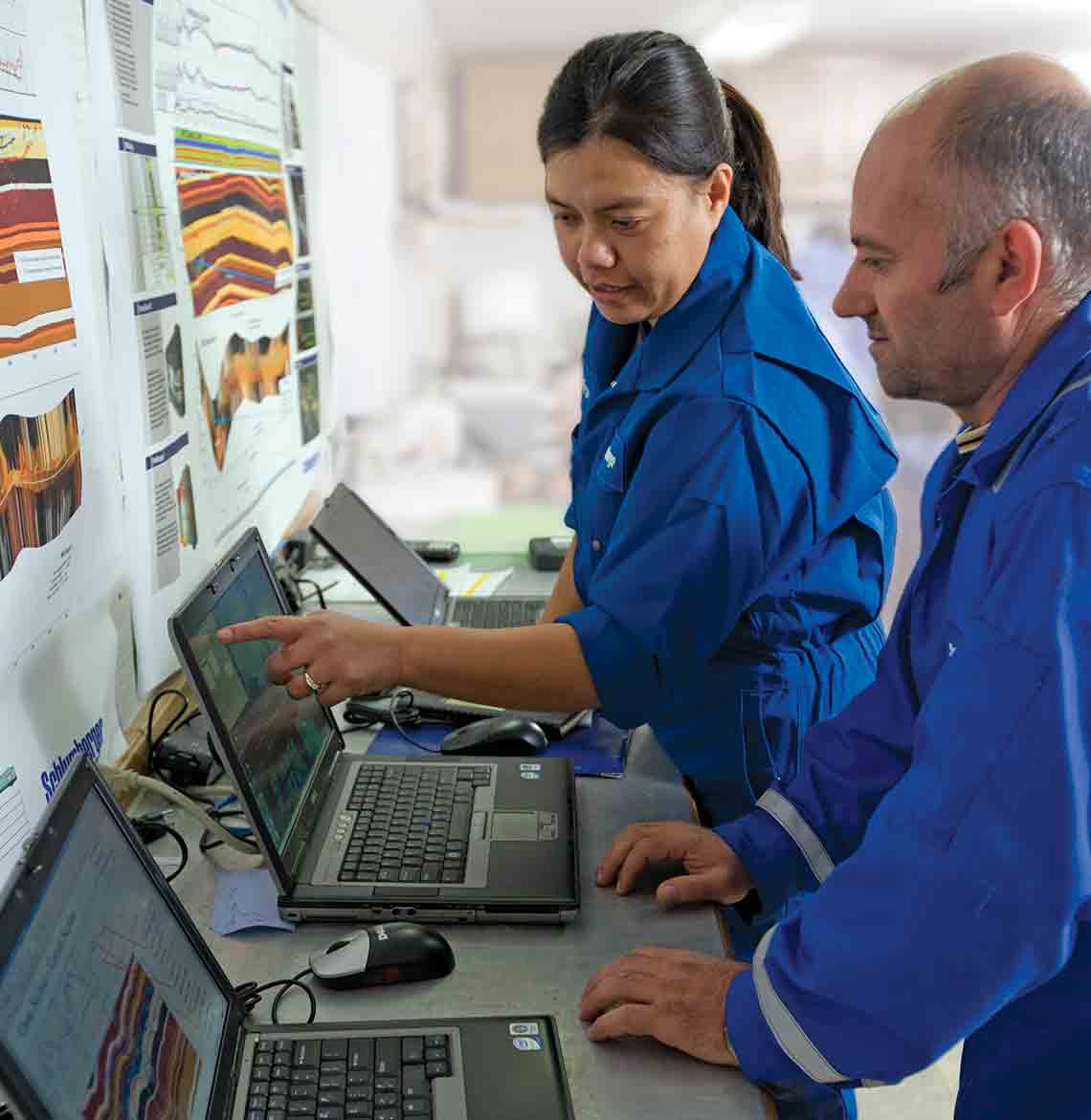 A woman and a man evaluating measurement images on 2 laptops