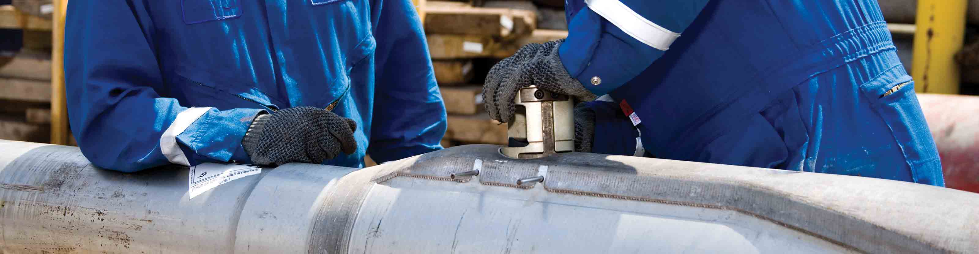 Two Schlumberger technicians making final preparations to a StethoScope formation pressure-while-drilling service tool