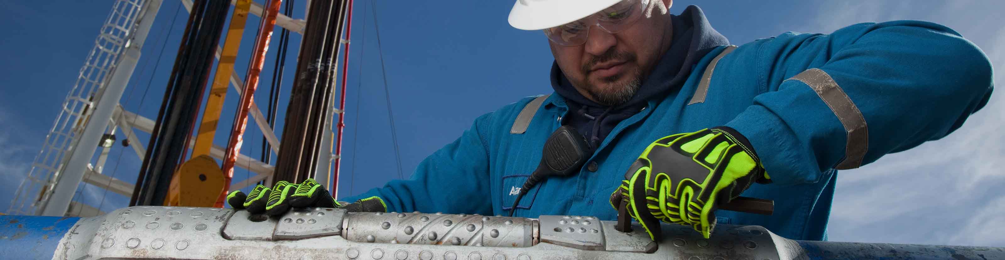 Schlumberger worker performing maintenance on an OnGauge torque-reduction sealed-bearing roller reamer.