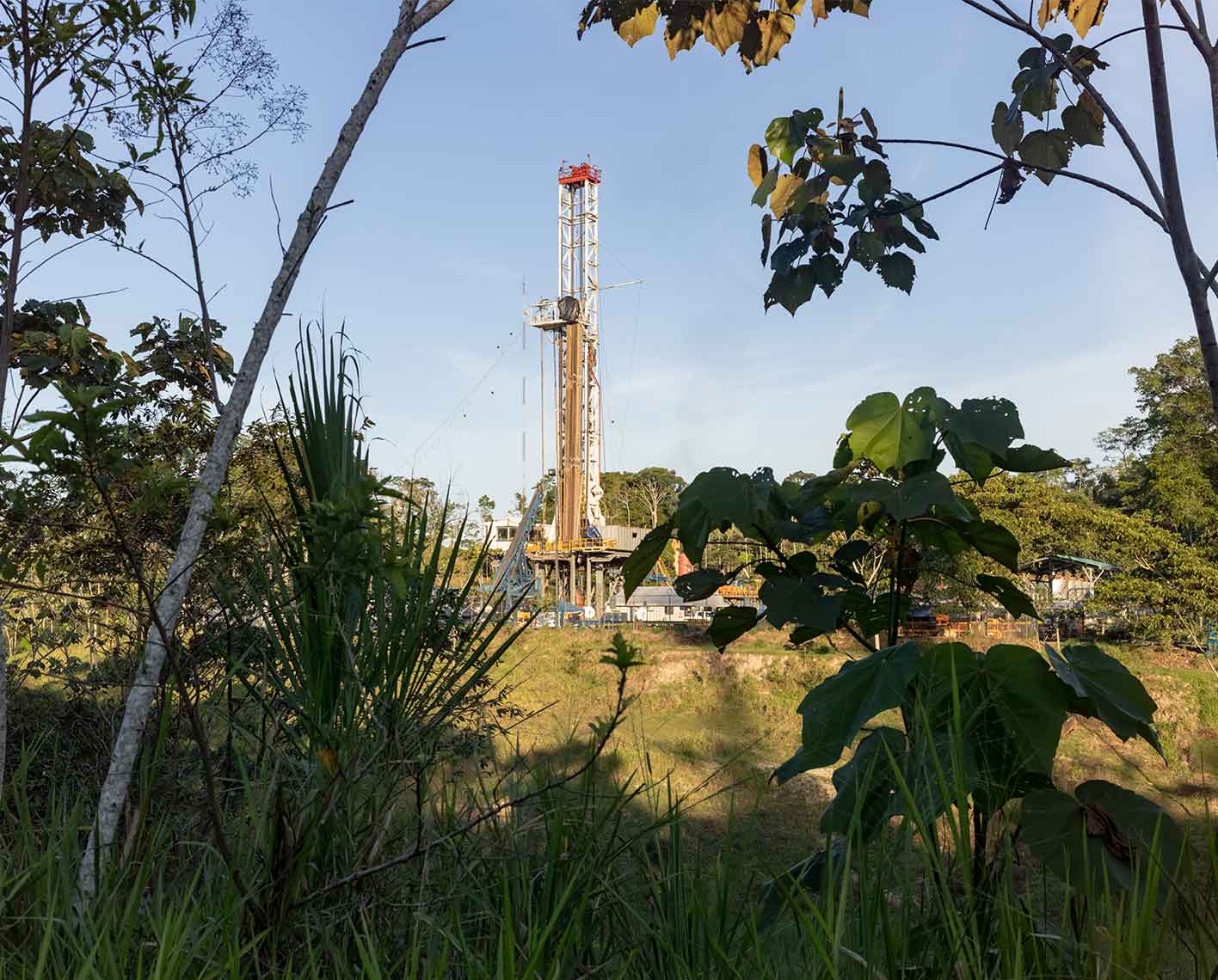 Land rig viewed through some forest trees