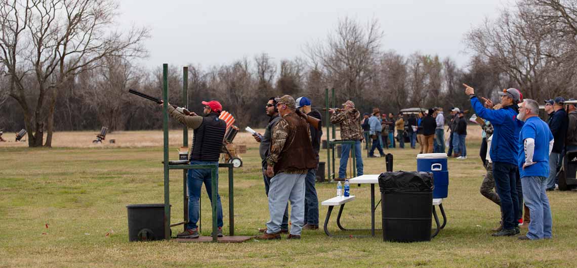 A team of shooters watching a team member