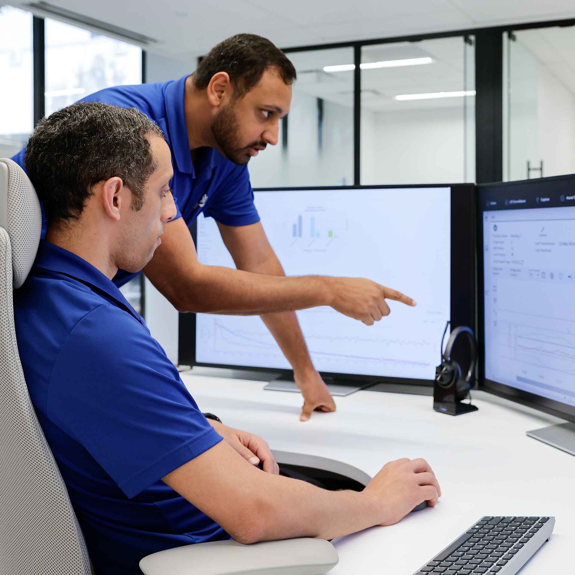 Two Performance Live center experts discussing displays on monitors.