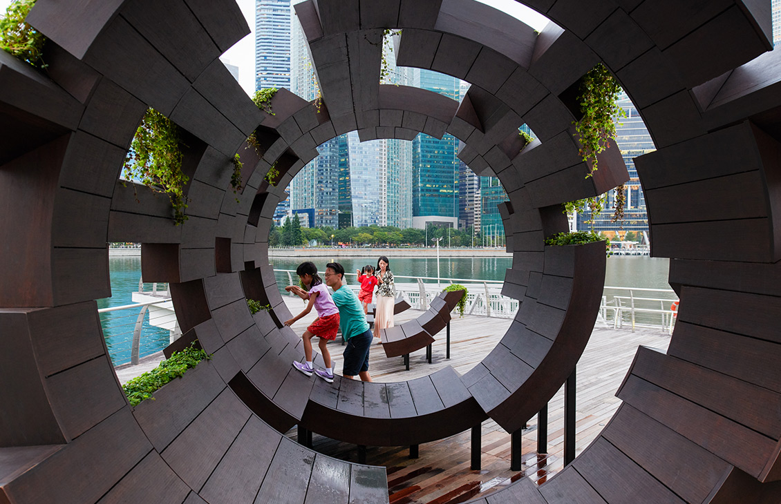 A father helping a child play in a round play structure