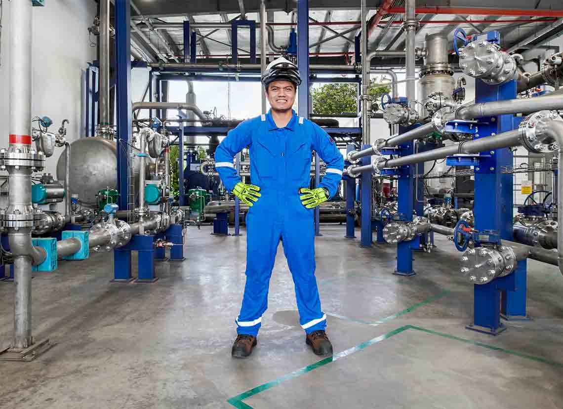 Man in blue coveralls standing in facility (Tier 1_ManufacturingFacility_Singapore_ASIA_15881)