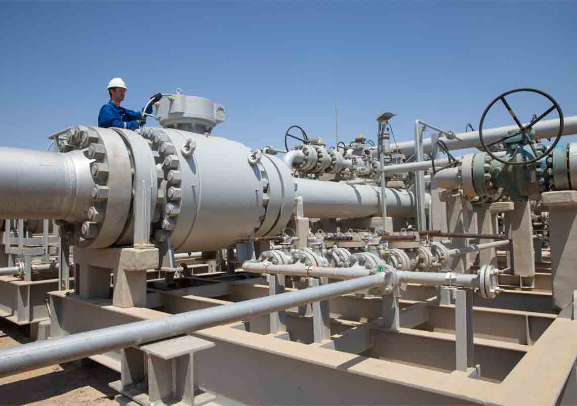 Photo of person in blue coveralls working with pipeline equipment (Sabriya GROVE Manual Inlet Valve with Person)