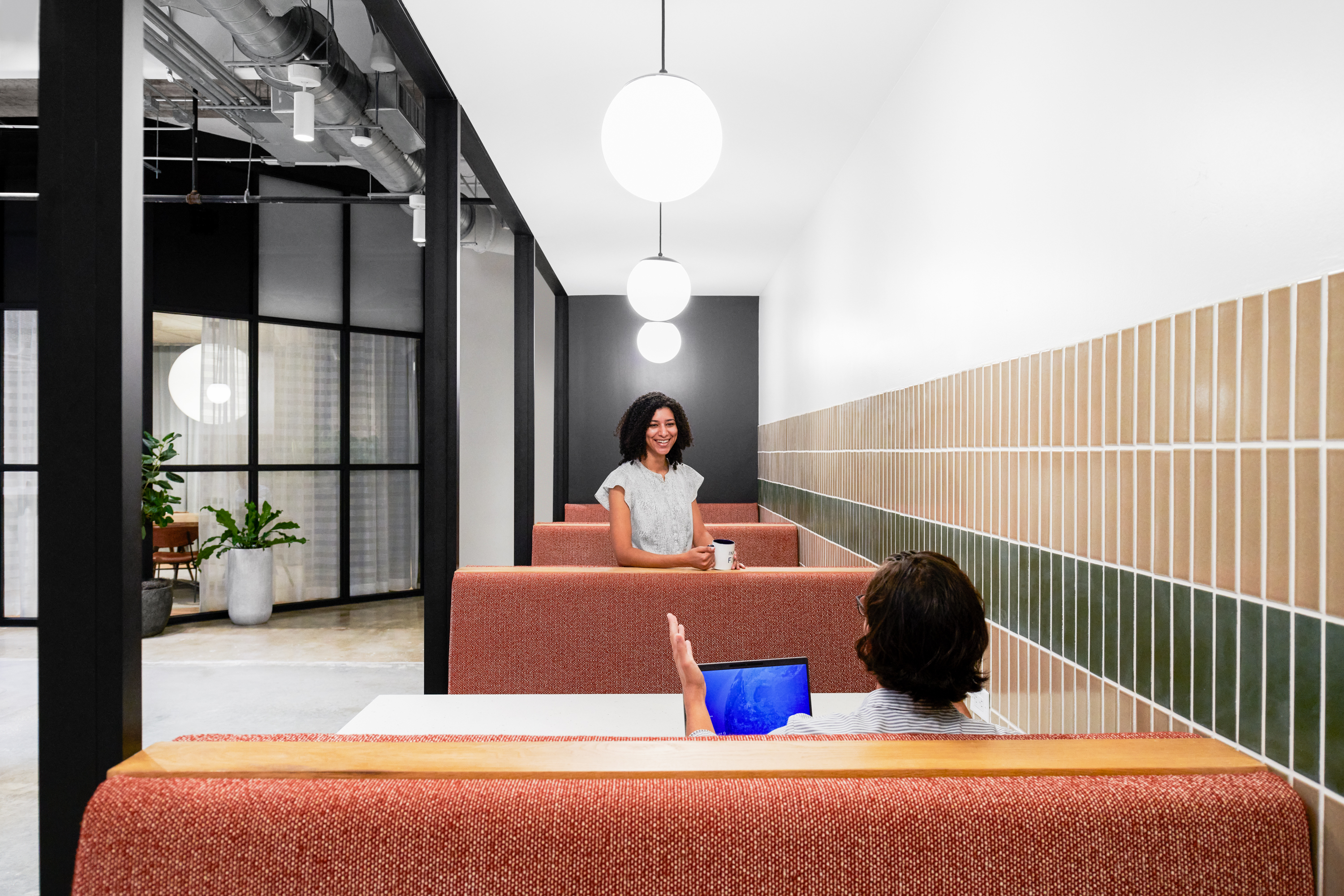 Man and woman in dining booths facing each other.