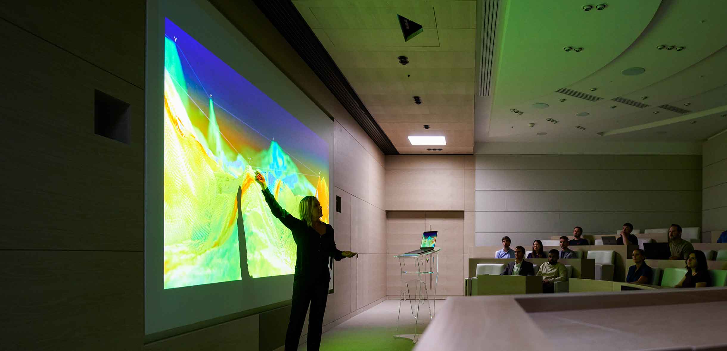 Woman giving a presentation to a crowd in an auditorium