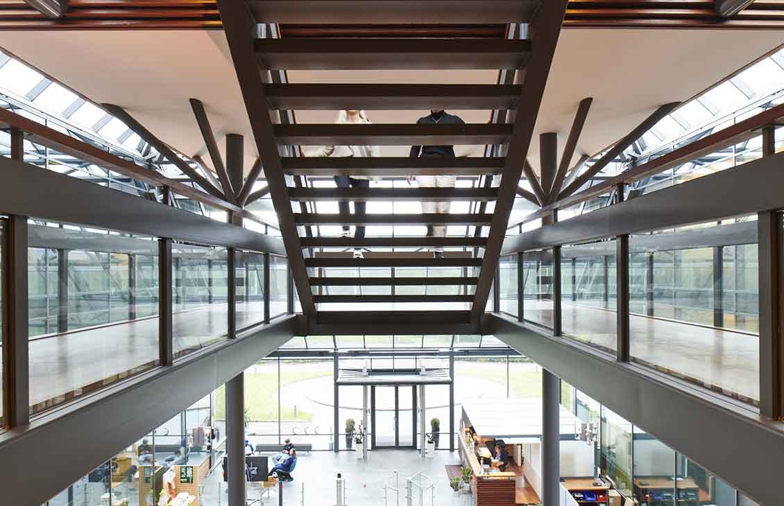 Photo peeking through back of open staircase in office building, two people walking up stairs