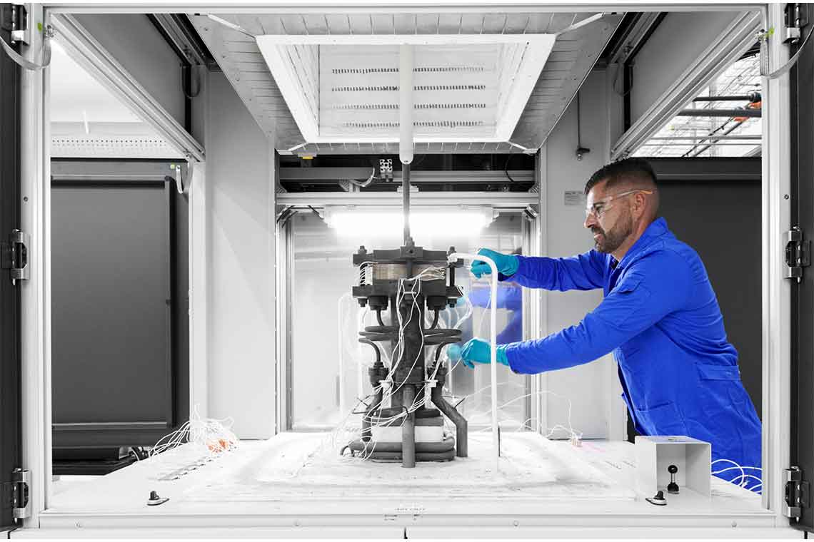 Man in blue coveralls and safety glasses working with hydrogen equipment