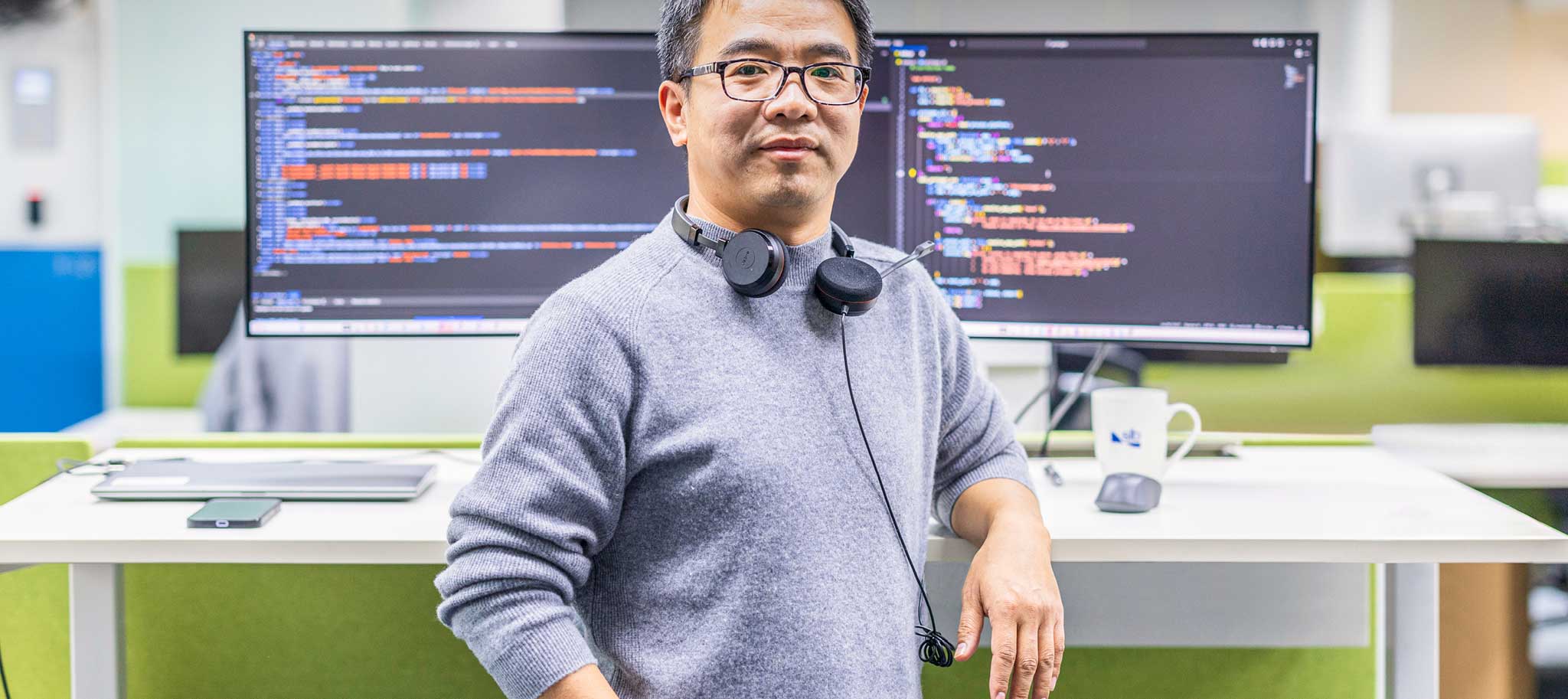man stood in front of 2 monitors