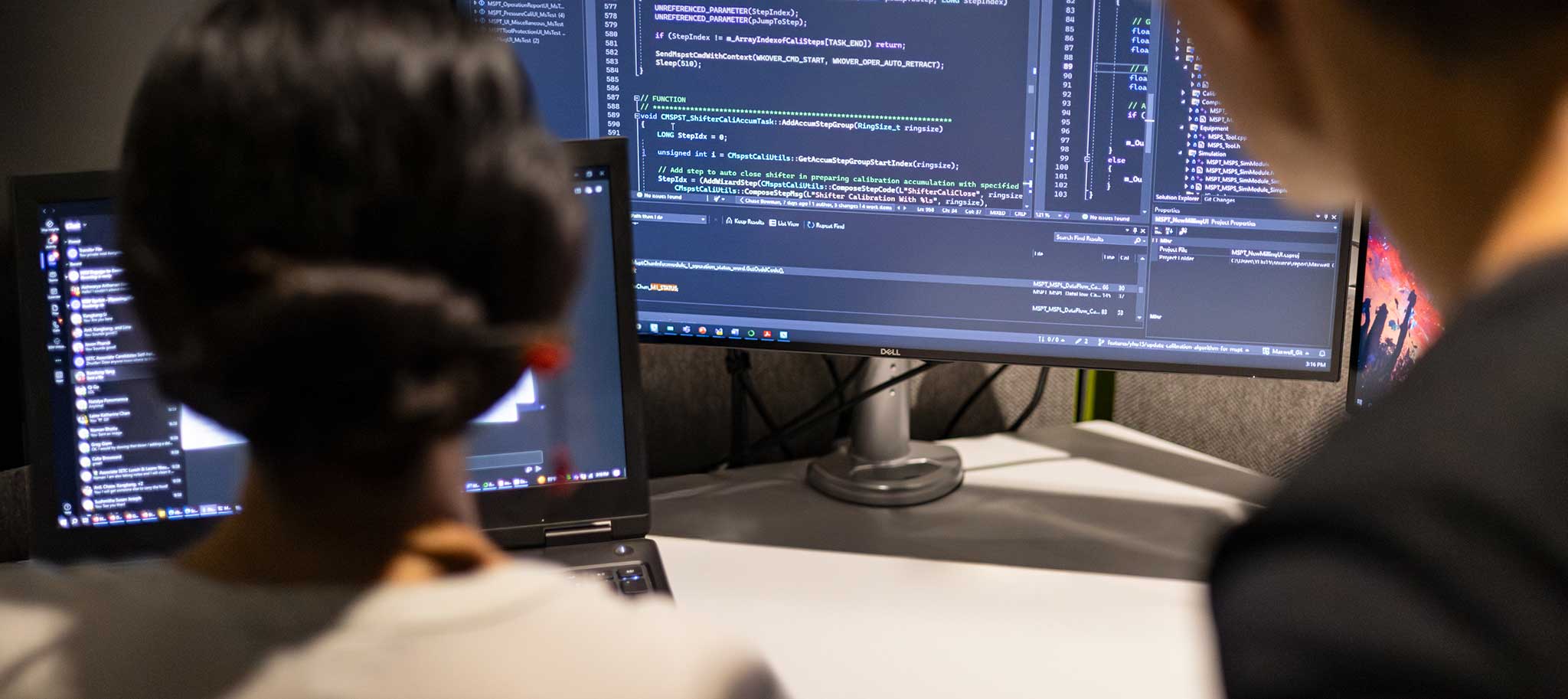 two people analysing code on a computer screens