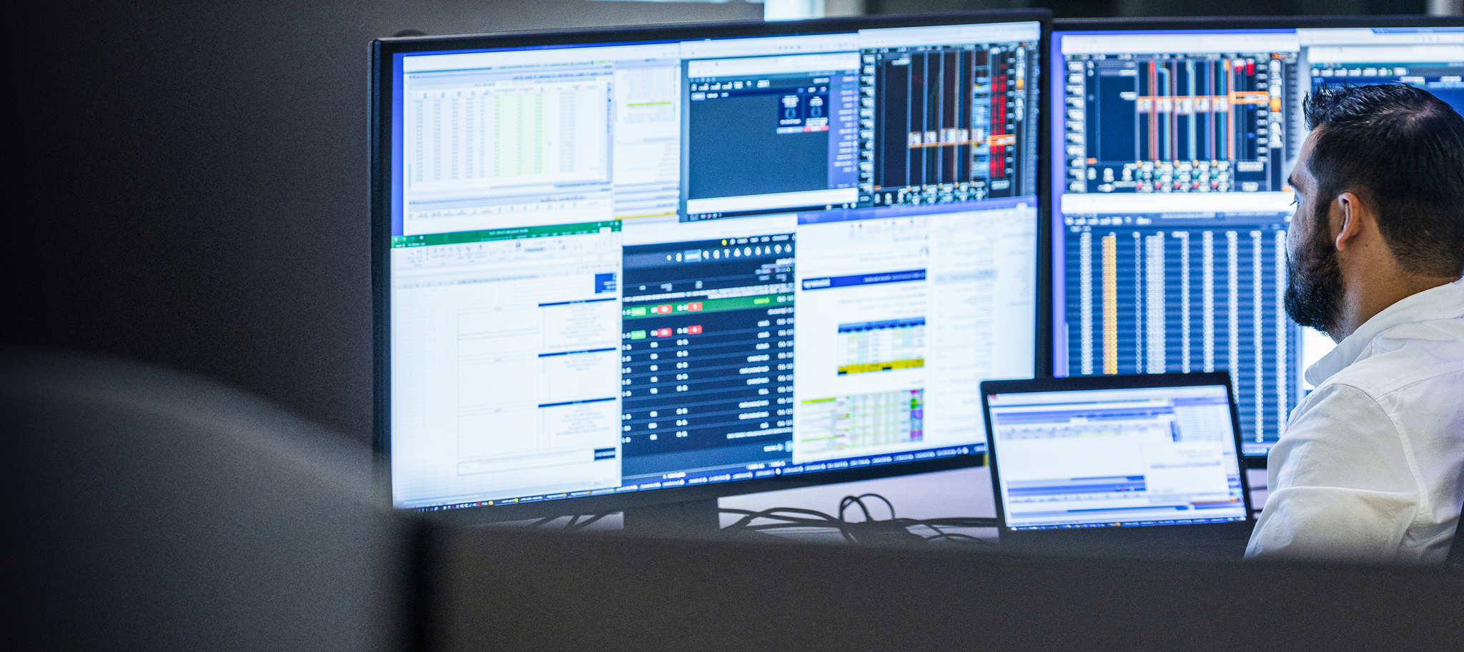 A person sitting in front of multiple screens