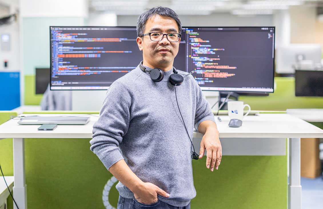 man stood in front of 2 monitors