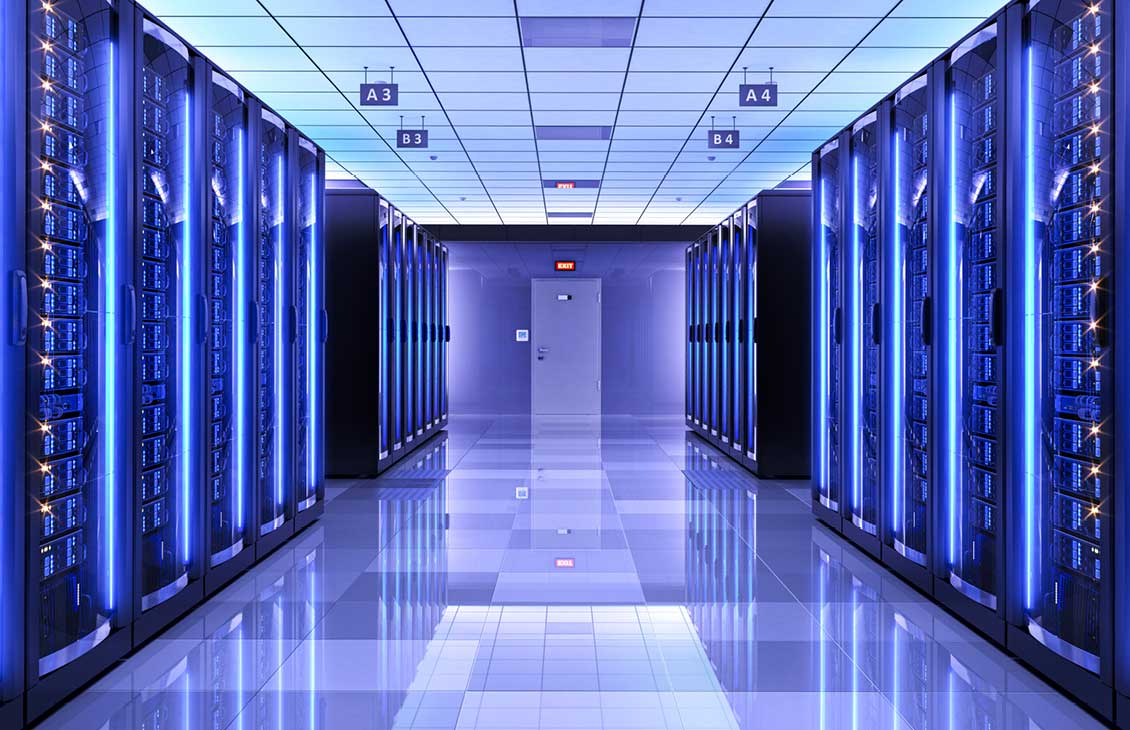 Hallway with glowing blue server racks in a data center.