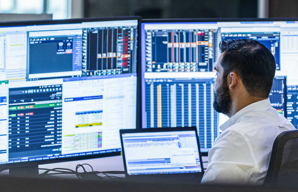 A person sitting in front of multiple screens
