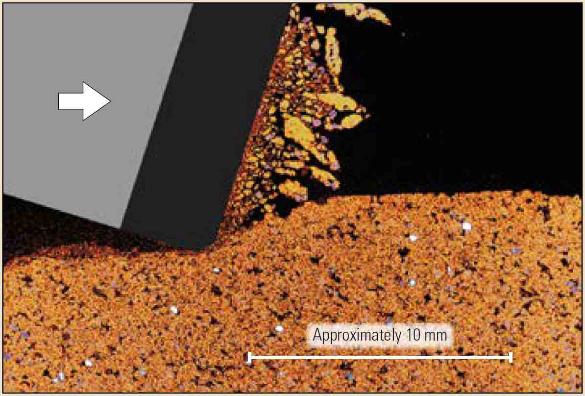 The action of a PDC cutter plowing through sandstone (orange) is shown in a cross section that was imaged using microCT scanning. 